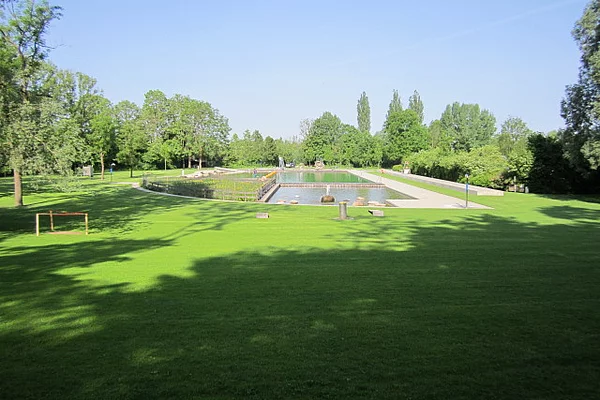 Naturfreibad Kaufering - Außenbereich mit Liegewiese und Blick auf die Schwimmbecken