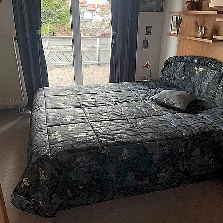 Ferienwohnung Witt, Schlafzimmer mit Bett und grauer Tagesdecke