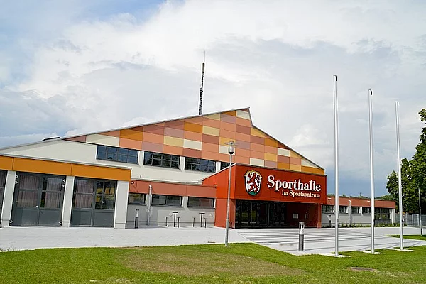 Sportanlage Kaufering - Dreifachsporthalle Eingangsbereich, Gebäude mit bunten rotfarbenen Platten und rotem Eingangsbereich 
