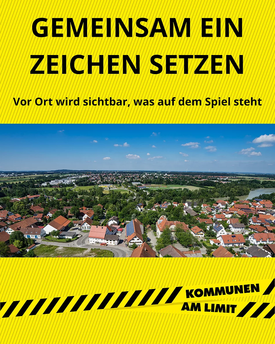 Luftaufnahme von Kaufering mit Wohnhäusern und viel Grün unter blauem Himmel, darüber gelber Balken mit dem Text 'GEMEINSAM EIN ZEICHEN SETZEN Vor Ort wird sichtbar, was auf dem Spiel steht' und darunter gelber Balken mit dem Text 'KOMMUNEN AM LIMIT'