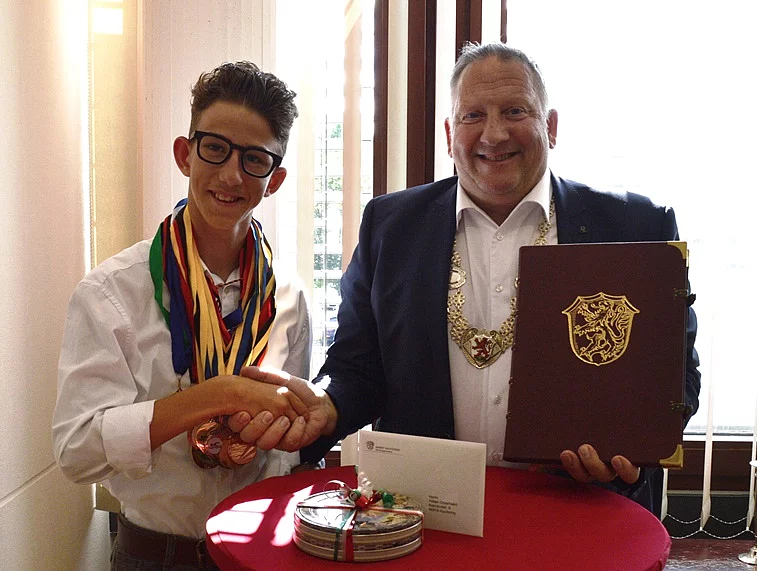 Alisan Omerbasic mit Bürgermeister Thomas Salzberger geben sich die Hand.