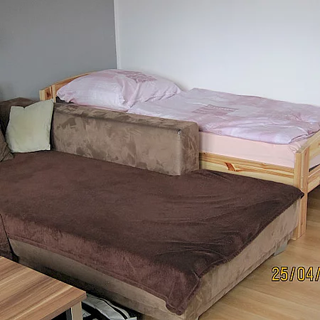 Ferienhaus Renate, Schlafzimmer mit brauner Couch und Zustellbett
