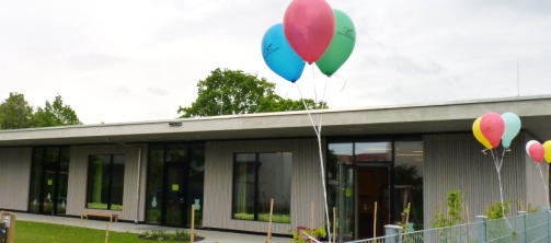 Foto der Außenansicht vom Kinderhaus Maria Himmelfahrt mit Luftballons am Zaun